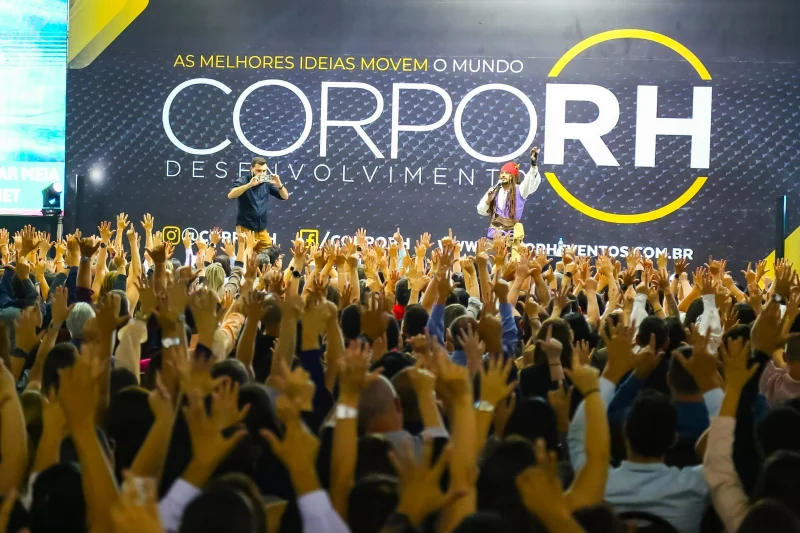 Plateia com mãos levantadas durante palestra Q9 no CorpoRH